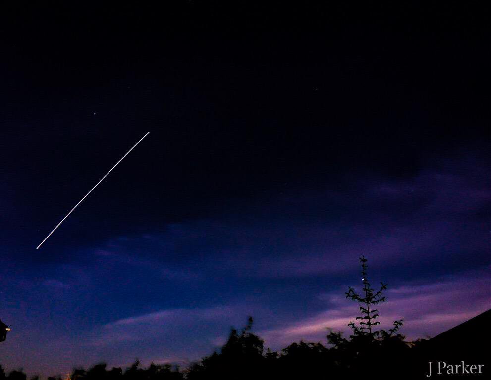 A photo of the ISS showing a trail